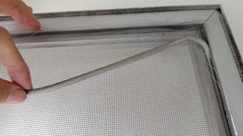 網戸のゴムを引っ張って外していくところ